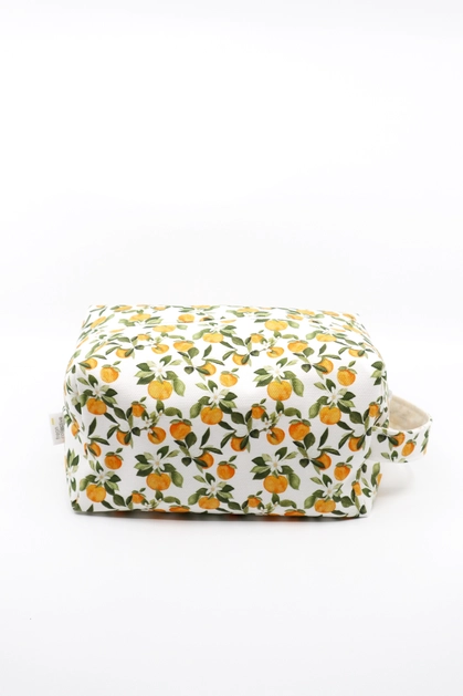 Makeup bag in Clementine print, with various small clementine fruits, white flowers and green leaves