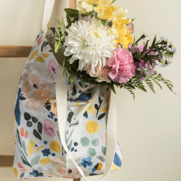 Tote bag in Sierra Florals, a colourful floral print, with a bouquet of flowers in it